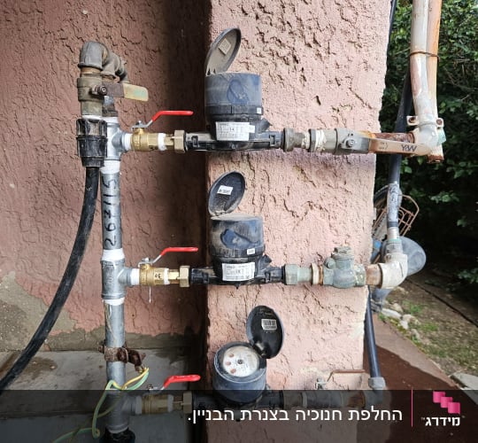 מד מים וצנרת על קיר חיצוני